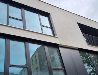 Fensterreinigung in Berlin zum Festpreis: Fassadenfenster werden mit eine Teleskopstange von außen geputzt
